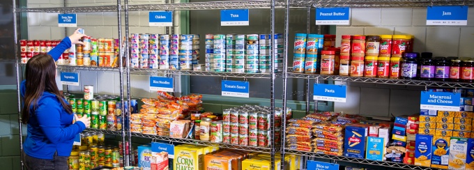 A student stocks shelves in the Blue Table food pantry. 