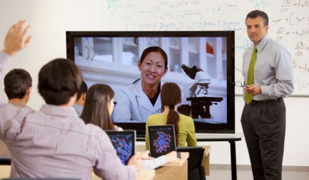 Instructor in Lync online meeting in a classroom.