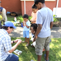 Doug Perrelli showing archaeological items to a family at the Michigan Street Baptist Church site in Buffalo, NY.