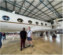 Zoom image: Associate Professor Adam Wilson with PhD student Festus Adegbola in front of the NASA GIII aircraft, which was in Cape Town, South Africa, for six weeks during the UB-led BioSCape Project. Festus spent about two months in Cape Town working with an international team, collecting data on bird diversity from ecosystems imaged by the aircraft.  His work will explore how plant functional diversity, as measured using cutting-edge remote sensing, influences bird populations and abundance. This work will improve our ability to understand and manage ecosystem conditions globally using remote sensing. 