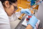 UB chemistry PhD student Anjula Kosswattaarachchi prepares to test a simple liquid-based battery containing a methylene blue solution. 