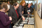 Tom Toles points out a photo to faculty members Bruce Jackson and Diane Christian during the opening on April 14 of an exhibition of his work in the Kaveeshwar Gallery on the fifth floor of Capen Hall. Photo: Douglas Levere