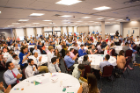 Roseanne Berger (blonde wearing white coat), senior associate dean for graduate medical education, walks among the tables of incoming residents. Photo: Douglas Levere