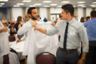 Jared DiBenedetto, Emergency Medicine resident, helps Reshvinder Dhillon, Pediatrics resident, into his long coat.