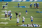 Team coaches guide members of the offensive and defensive units through drills.