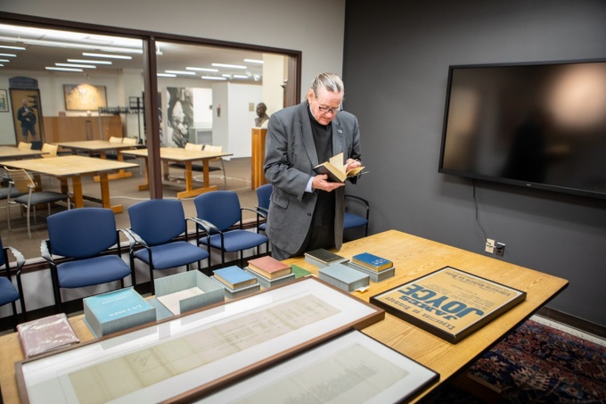 Rev. Msgr. J. Patrick Keleher (“Father Pat”), director and campus minister for the Newman Center at UB, stands near the James Joyce Collection within the University at Buffalo Libraries.