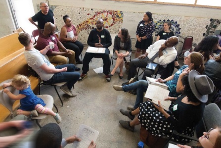 A professor discusses a topic with students and community members.