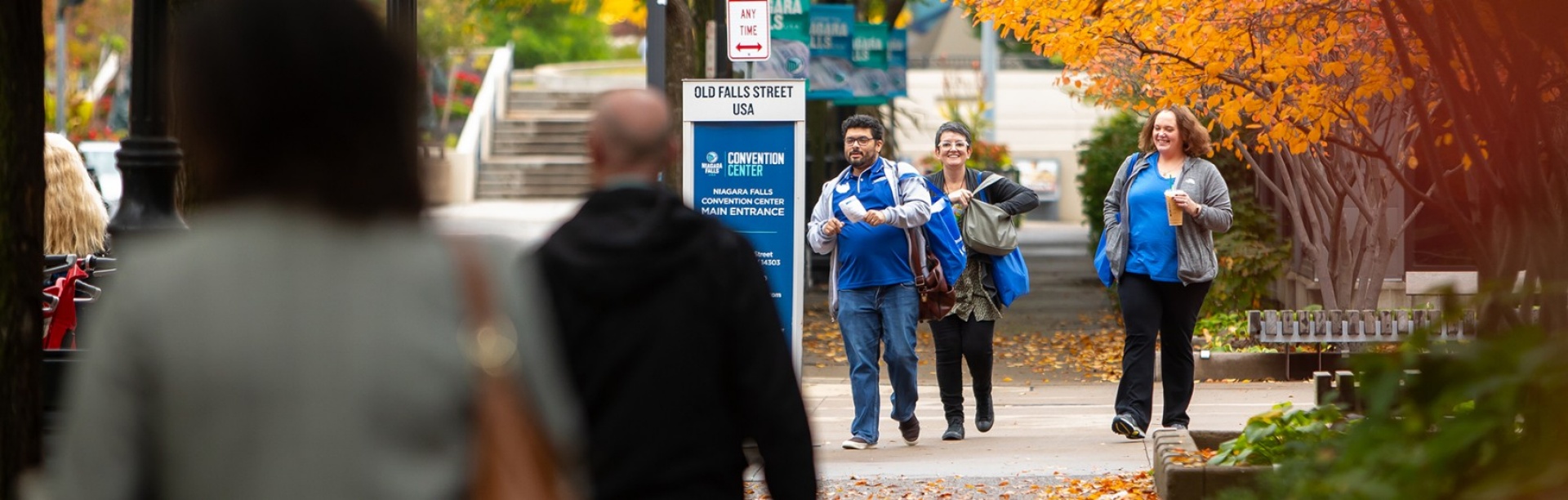 UB Business Day 2023 attendees walk on the sidewalk outside the Niagara Falls Convention Center in Autumn. 