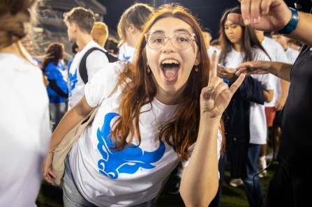 UB student in a crowd with UB Horns Up hand gensture.