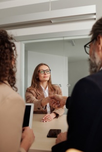 An interviewee shaking hands with a new employer, in the next stage of her career.
