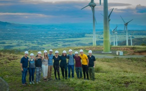 group of people with windmills in the background.