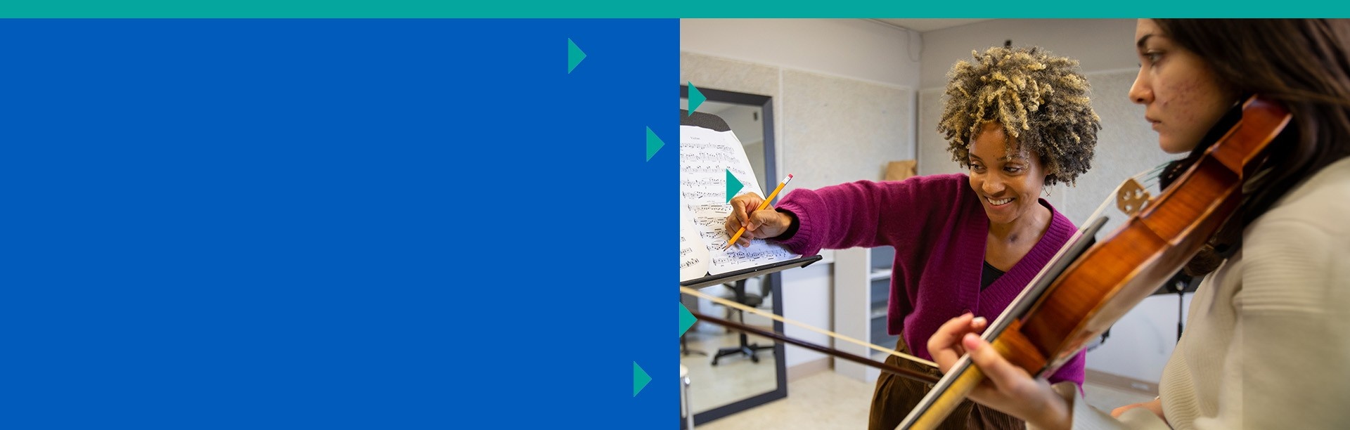 A music instructor annotating a score with a student violinist. 