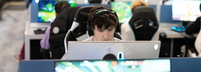 Students sitting and playing video games in the esports lounge.