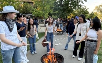 Residents roasting marshmallows over bonfire at RHA Rodeo event.