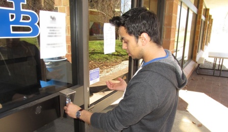 student swiping u b card to get access to a building.