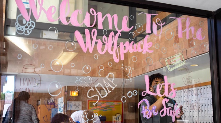 "Welcome to the Wolf Pack" drawn in paint on a window.