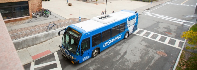 Stampede shuttle bus driving outside Greiner Hall.