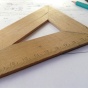 Wooden triangular ruler sitting on table. 