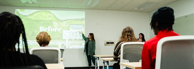 A student presenting in front of a class. 