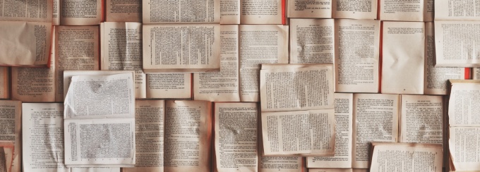 Image of books layered on a table. 