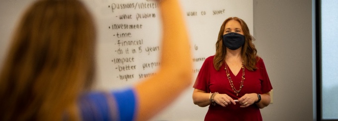 Faculty member calling on student raising hand. 