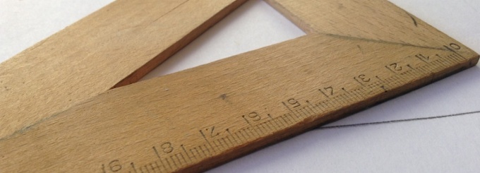 Wooden triangular ruler sitting on table. 