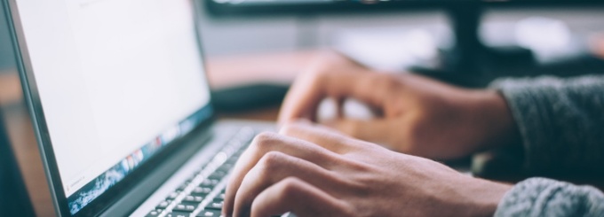 Photo of hands typing on a computer. 