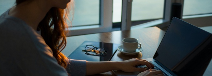 Photo of woman typing on a computer at a desk. 