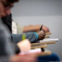 Students taking notes in a classroom. 