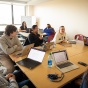 Students sitting around a desk in a classroom. 