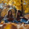 Students sitting in a grassy area surrounded by leaves studying. 