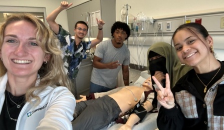 CLIMB UP 2024 participants (left to right) Mia Piede, Rafael Ortiz, Victor Mina, Khalida Khatun and Jeishlyn Galloza Quiles in the Behling Simulation Center at the Jacobs School of Medicine and Biomedical Sciences.