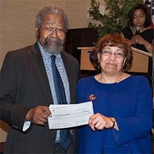 Two CSTEP mentors holding a scholarship check bearing their names.