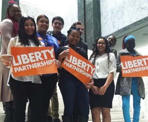 Group of students holding orange Liberty Partnerships signs.