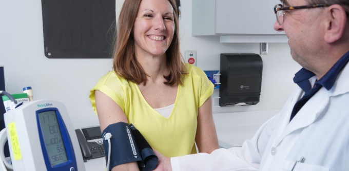 A doctor checks a patient's blood pressure.