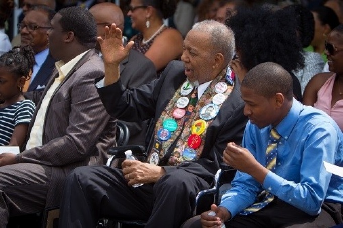 Arthur O Eve sitting down and raising his hand.