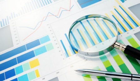 paper reports and charts on desk.