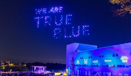 A light show over Baird Point displays the saying, "We are True Blue.". 