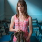 A veteran in the classroom holding combat boots. 