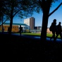 People in silhouette walking outside on the North Campus. 