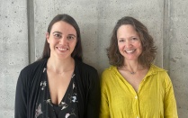 Two women smiling at the camera. 