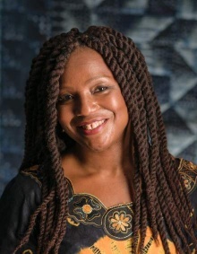 Image of a smiling woman against a gray background. 