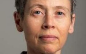 Woman with short dark hair, smiling at the camera.