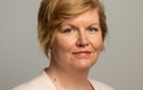 Woman with light hair, smiling at the camera.