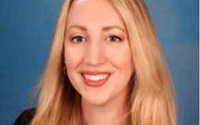 Person with blonde hair smiling at the camera.