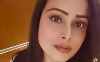 Person standing indoors, looking at the camera.