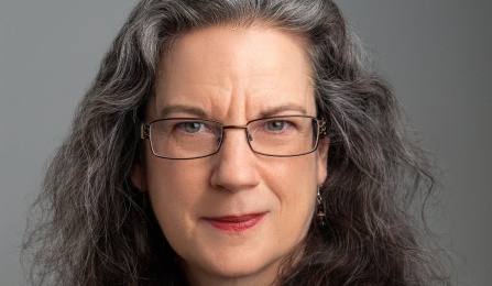 Zoom image: Woman in red blazer, smiling at the camera. 