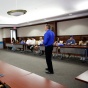 tim matthews teaching a class in a big room with desks in a horseshoe shape. 