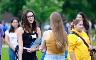 group of students outside, with two of them having a conversation.