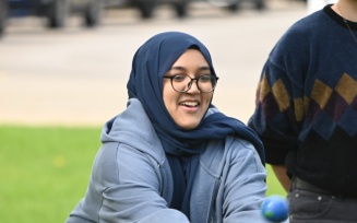student sitting outside and smiling.